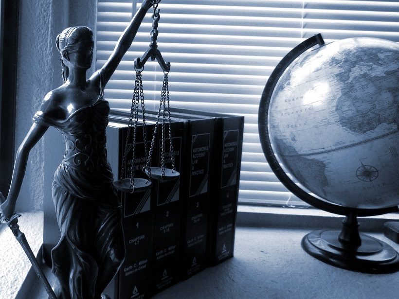 Goddess of Justice with civil codes and globe representing specialised legal translation services.