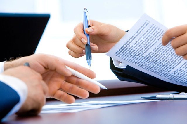 Proofreader holding a pen over a document, illustrating careful proofreading services.